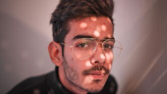 man in black crew neck shirt wearing silver framed eyeglasses