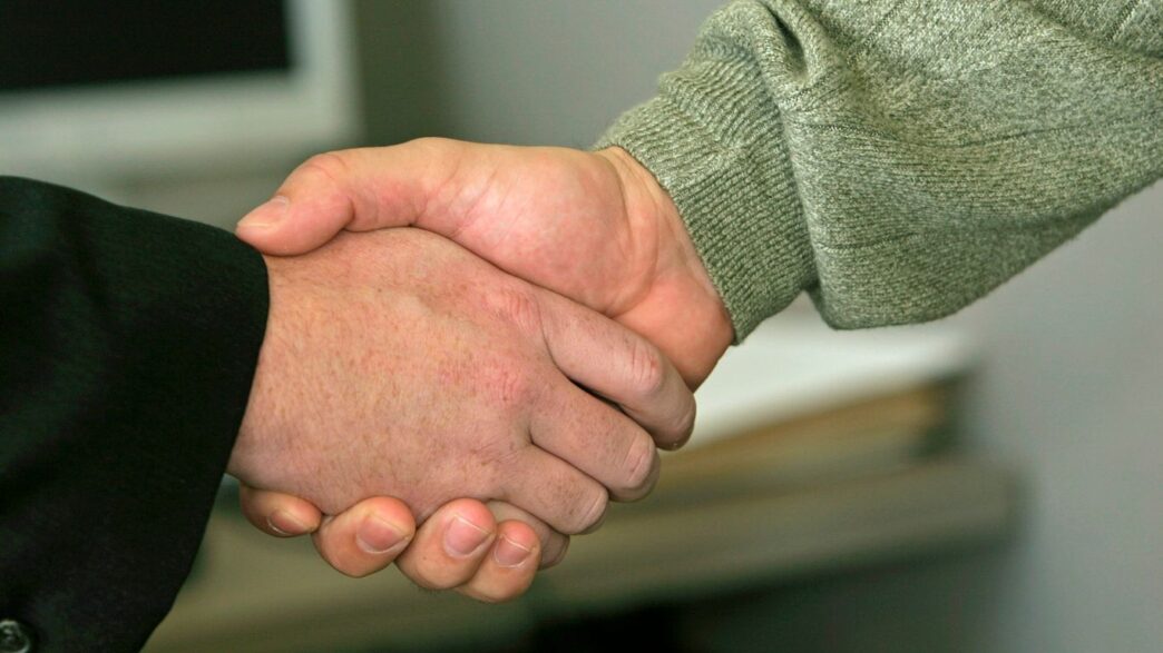 a close up of two people shaking hands