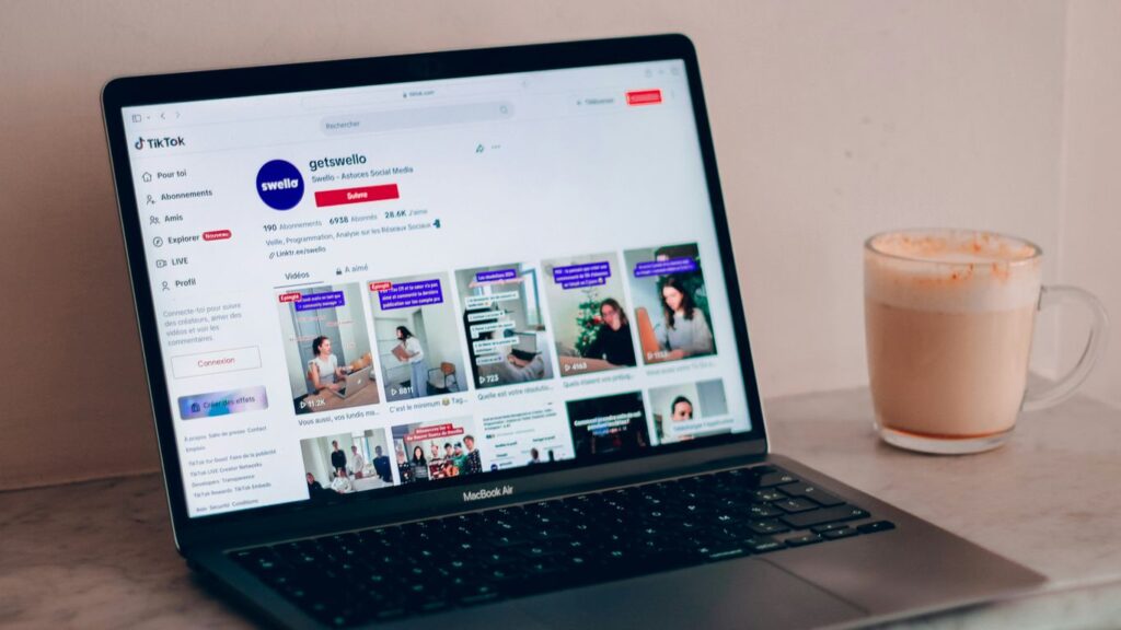 a laptop computer sitting on top of a table next to a cup of coffee