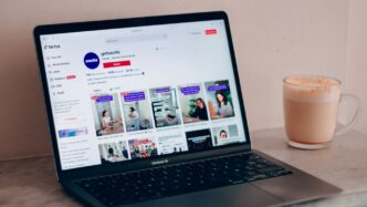 a laptop computer sitting on top of a table next to a cup of coffee