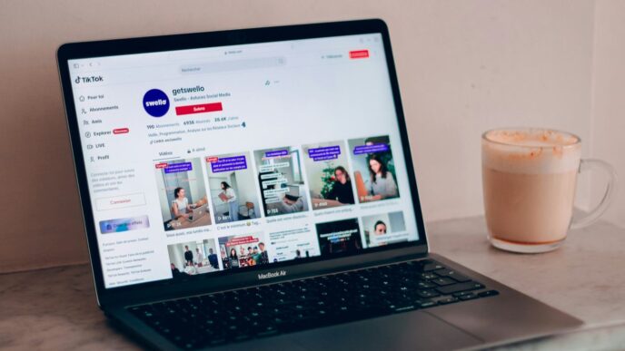 a laptop computer sitting on top of a table next to a cup of coffee