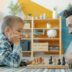 Father and son playing chess on the floor.