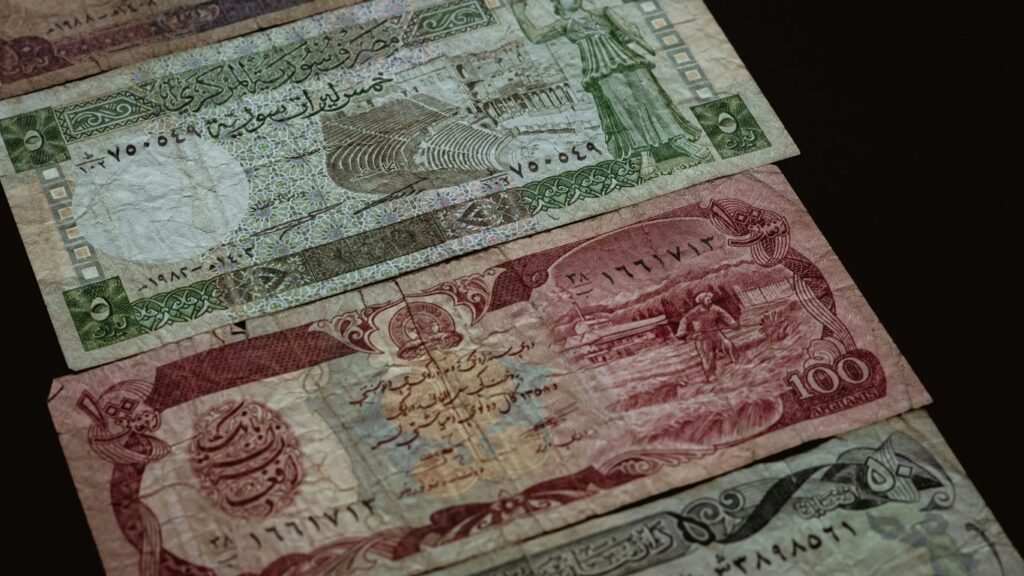 three banknotes on brown surface