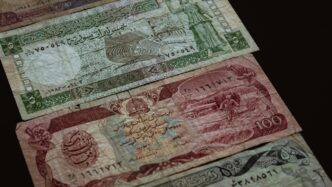 three banknotes on brown surface