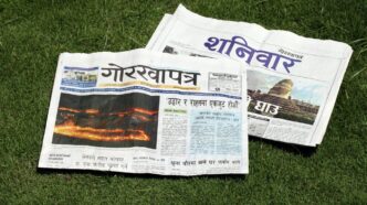 A newspaper laying on top of a lush green field