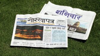 A newspaper laying on top of a lush green field