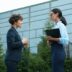 Two businesswomen talking outside modern building