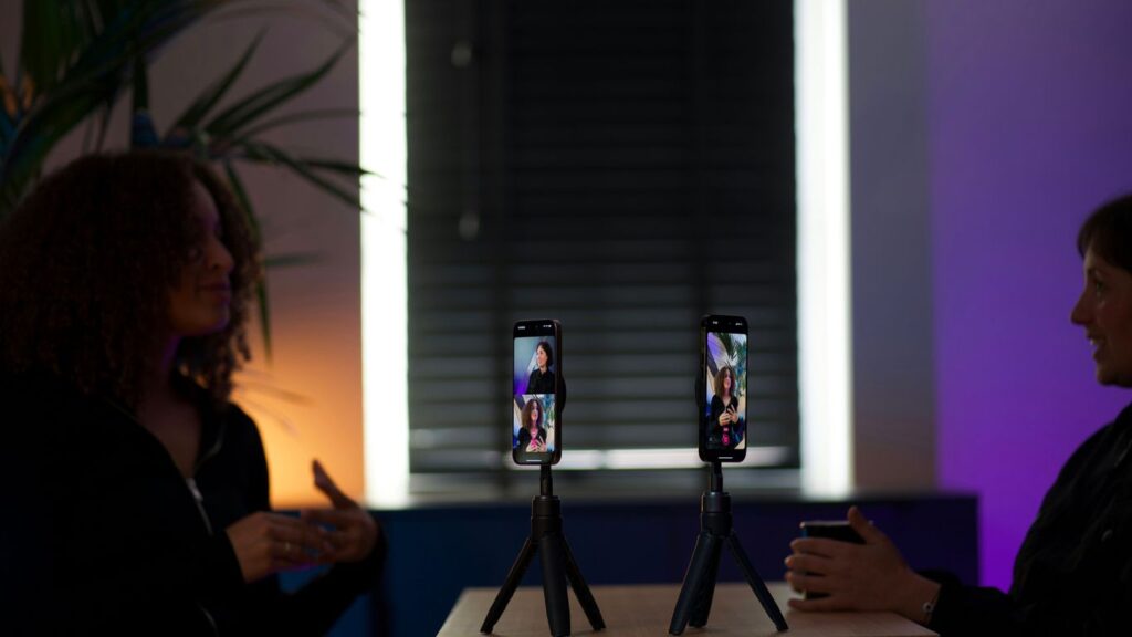 Two smartphones on tripods displaying video calls