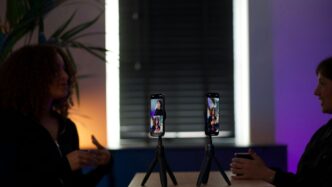 Two smartphones on tripods displaying video calls