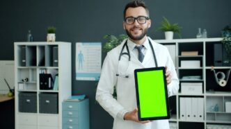 Doctor holding a tablet with a green screen.