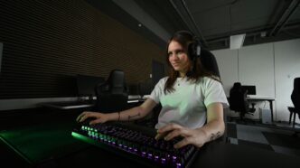 A woman sitting at a desk with a keyboard and mouse