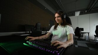 A woman sitting at a desk with a keyboard and mouse