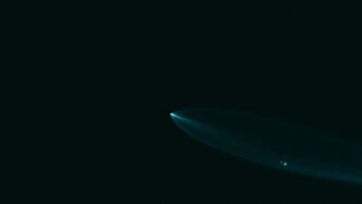 A surfboard is floating in the dark water