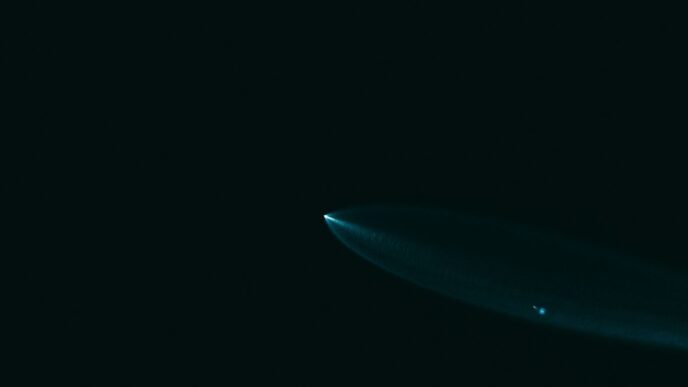 A surfboard is floating in the dark water