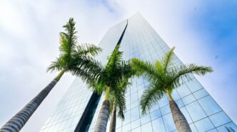 a tall building with palm trees in front of it