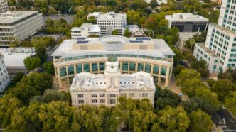 Historic building surrounded by lush green trees.