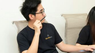 men's black crew-neck shirt holding black pencil close-up photography