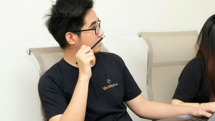 men's black crew-neck shirt holding black pencil close-up photography