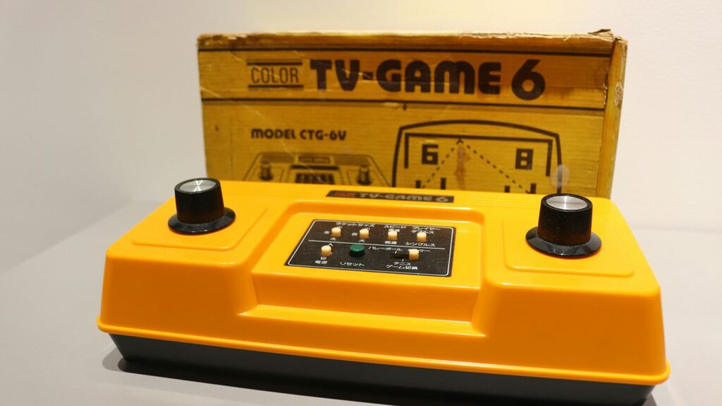 A yellow TV game sitting in front of a box