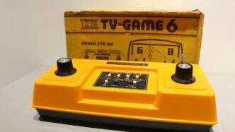 A yellow TV game sitting in front of a box