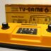 A yellow TV game sitting in front of a box