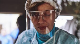 woman in teal scrub shirt wearing white head band