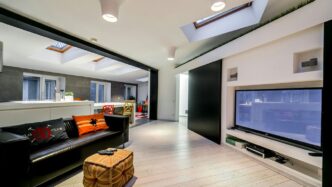 a living room with a black couch and a flat screen tv