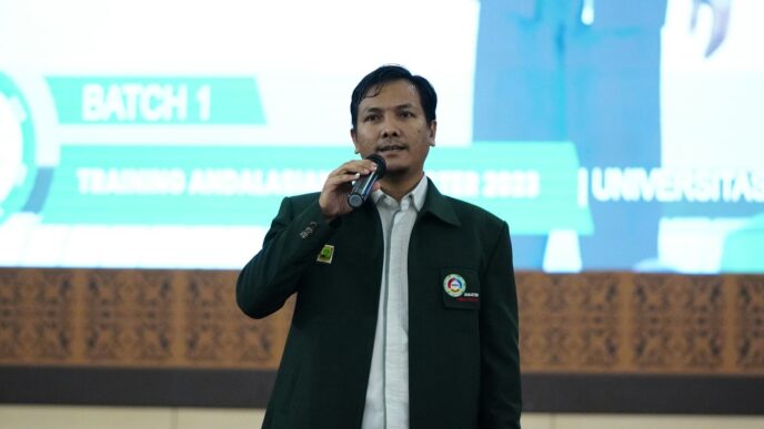 a man standing in front of a screen talking on a cell phone