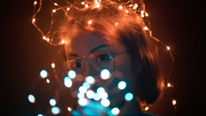 woman wearing brown framed eyeglasses with string lights on her head