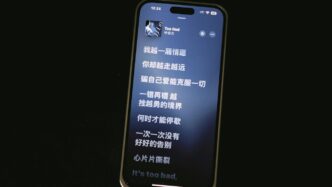 A phone displays song lyrics in chinese.