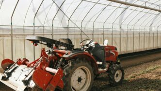 a red tractor is parked in a greenhouse