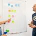 a man and a woman standing in front of a white board