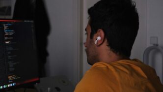 A man sitting in front of a computer monitor