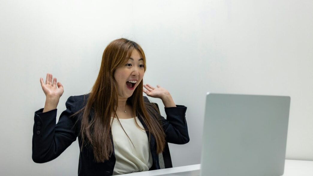 a woman sitting in front of a laptop computer