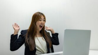 a woman sitting in front of a laptop computer