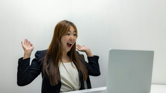 a woman sitting in front of a laptop computer