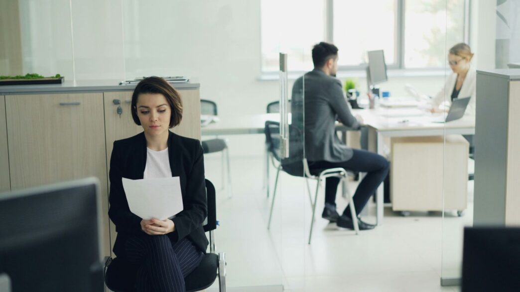 Woman sitting in office holding papers