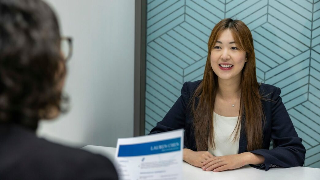 a woman sitting at a table with a piece of paper in front of her