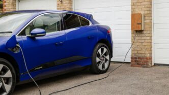 A blue electric car plugged in to a garage