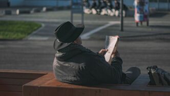 man in black hoodie reading book