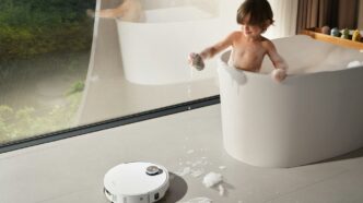 Child playing in bathtub with robot vacuum cleaner