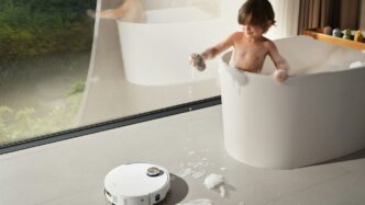 Child playing in bathtub with robot vacuum cleaner