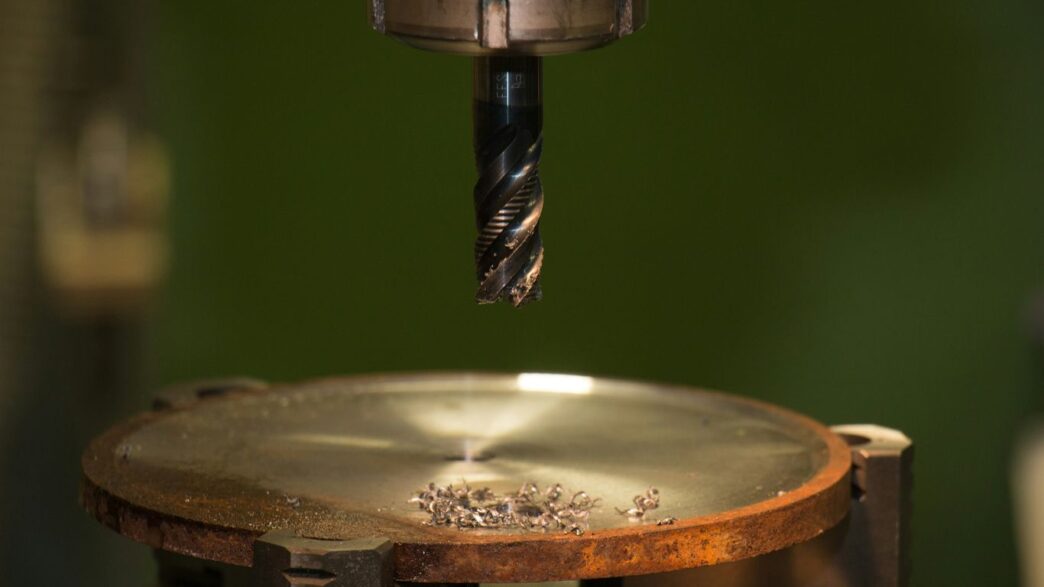 gray stainless steel drill bit about to reach the bottom