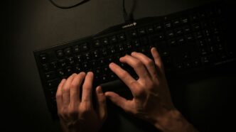 a person is typing on a black keyboard