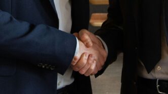 Business partners shake hands, making a deal.