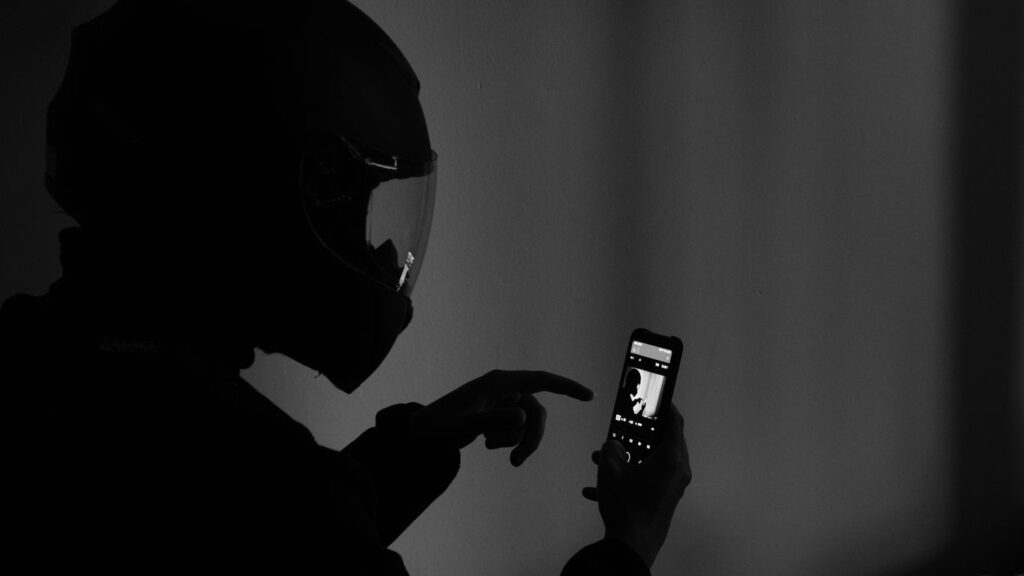 grayscale photography of man using smartphone