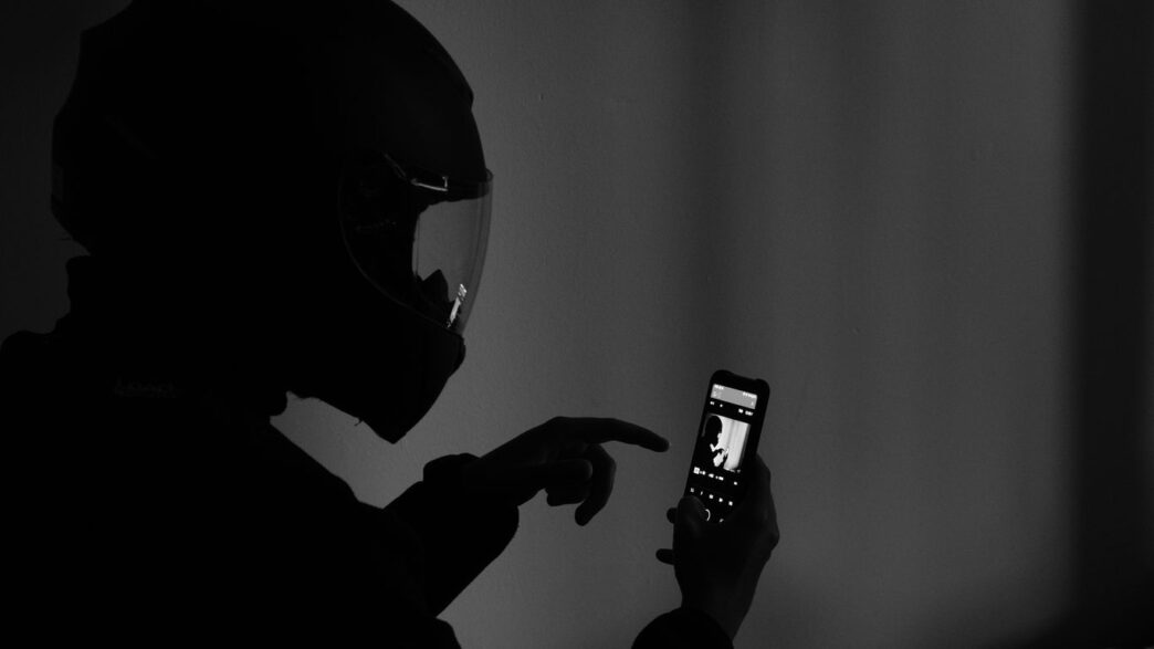 grayscale photography of man using smartphone