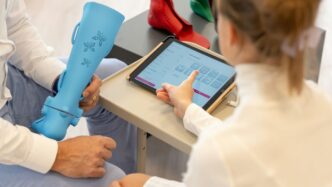 a woman sitting on a table using a tablet