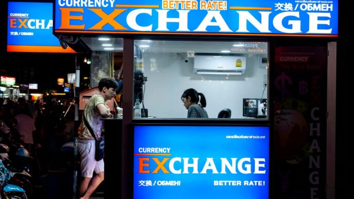 man in gray short standing near counter of currency exchange