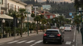 a car driving down a street next to tall buildings